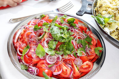 Angela Carnelutti – Italian Catering Zurich Fresh tomato salad with red onions and basil alongside Italian pasta by Angela Carnelutti in Zurich