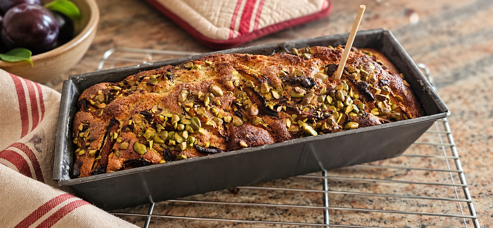 Testing the baked plum cake with a wooden skewer