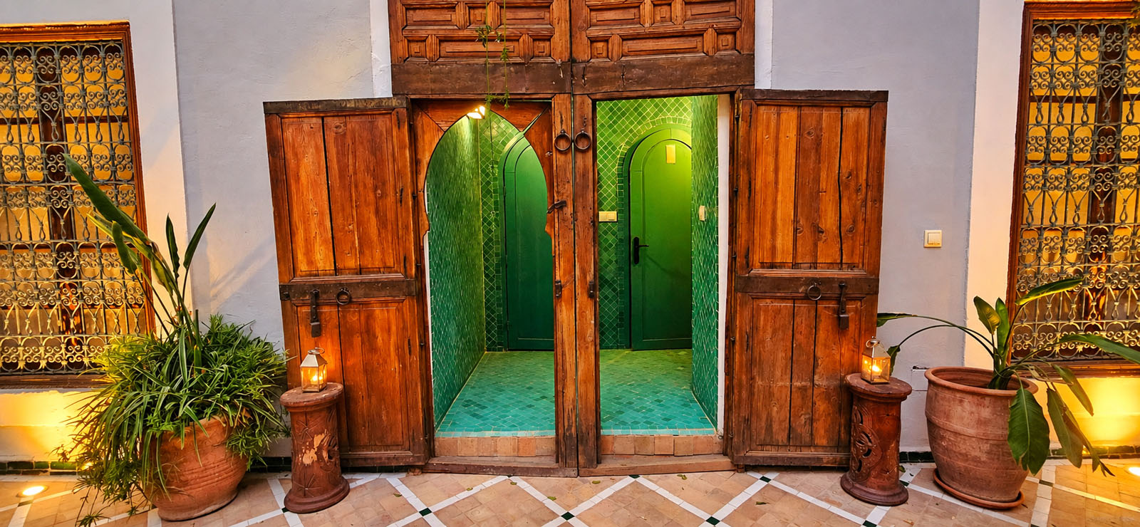 Traditional wooden courtyard doors with green Moroccan tiles at Riad Le Rihani Marrakech